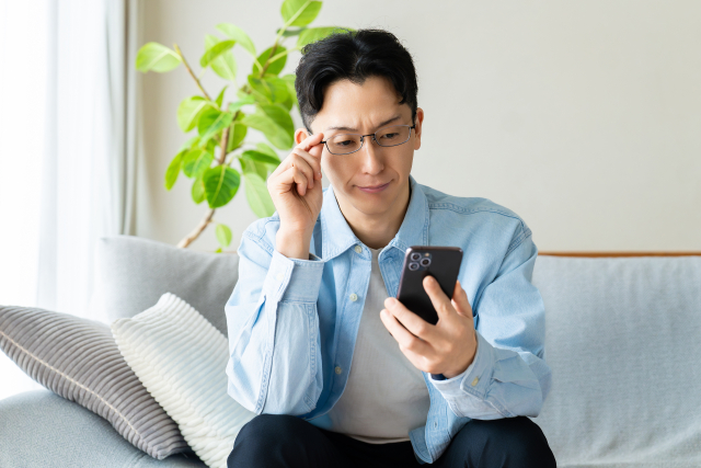 真剣な表情でスマホを見る男性